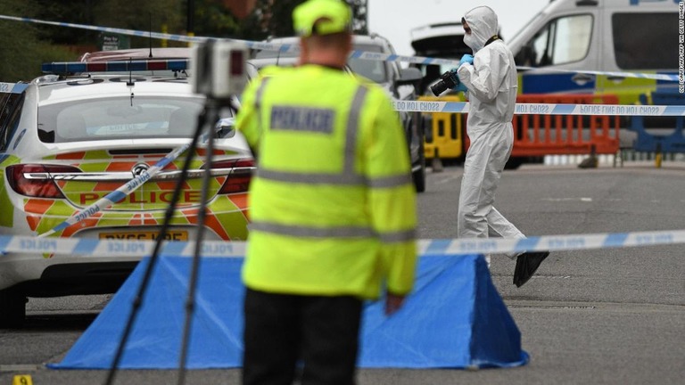 犯行現場で証拠を集める係官/OLI SCARFF/AFP/AFP via Getty Images