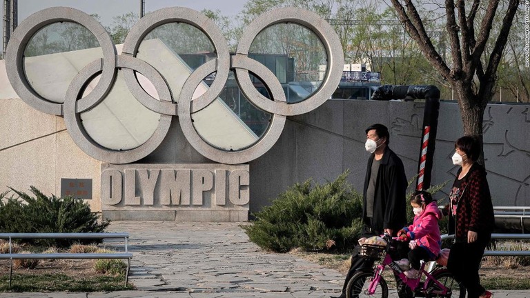 ２００８年の北京オリンピックのメイン会場前を歩く人々＝３月２３日、北京/Nicolas Asfouri/AFP/Getty Images