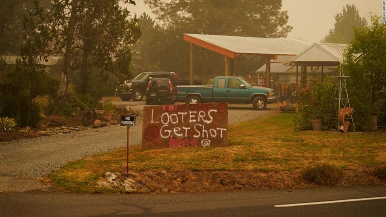 山火事に見舞われた米オレゴン州の住民が、略奪者に警告する看板を立てている/John Locher/AP