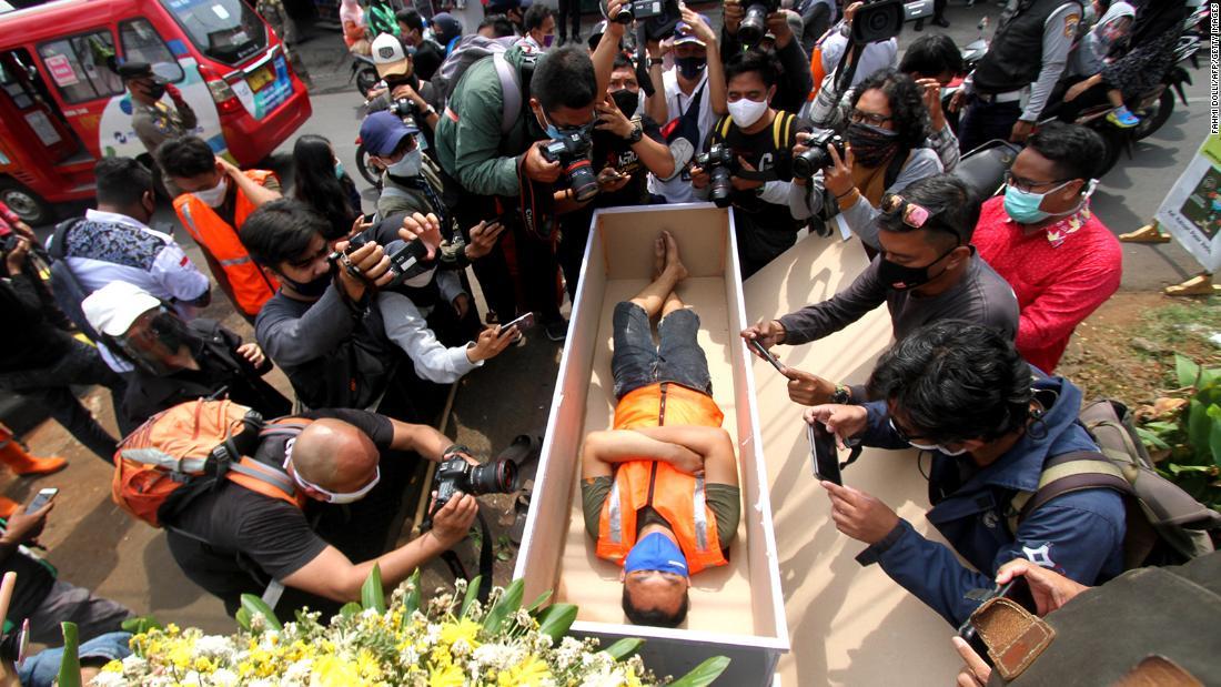 公共の場でフェースマスクを着用していなかった男性が刑罰として棺に横たわった＝３日、ジャカルタ/Fahmi Dolli/AFP/Getty Images