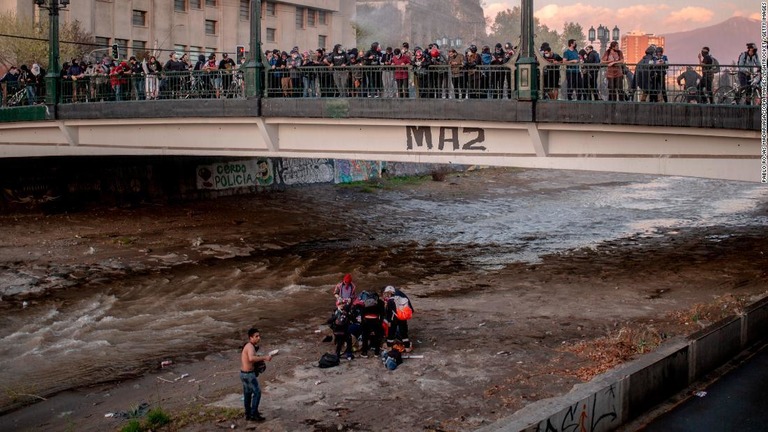 事件後、マポチョ川で少年が救急隊から手当てを受ける様子/Pablo Rojas Madariaga/SOPA Images/LightRocket /Getty Images