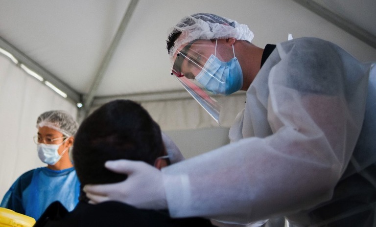 仏パリで新型コロナウイルスの検査を行う医療従事者/Nathan Laine/Bloomberg via Getty Images