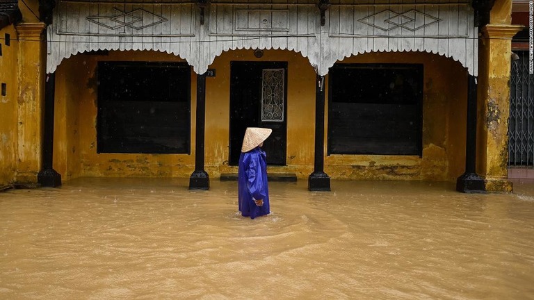 冠水した道路を歩く女性＝１７日/Manan Vatsyayana/AFP/Getty Images
