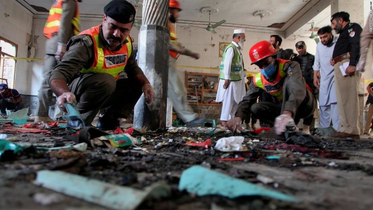 爆発の現場を調べる警察官＝２７日、パキスタン・ペシャワル/Muhammad Sajjad/AP