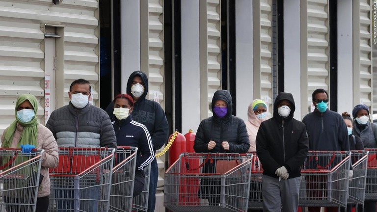 マスクを着けて食料品店の前に列を作る人々/Chip Somodevilla/Getty Images