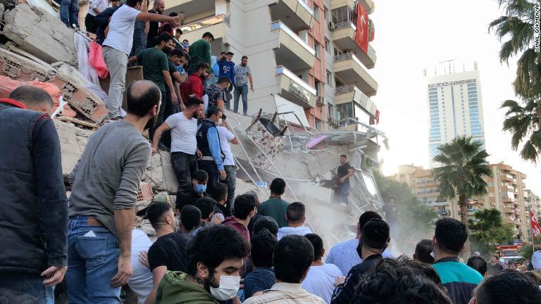 倒壊した建物に閉じ込められた住民を助け出そうとする人々＝３０日、イズミル/Ismail Gokmen/AP