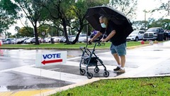 マイアミの期日前投票の会場に雨の降る中徒歩で向かう男性＝１０月１９日