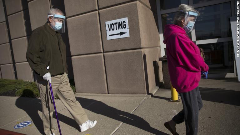マスクとフェースシールド姿で投票の列に並ぶ夫妻＝１０月６日、オハイオ州コロンバス/Maddie McGarvey/The New York Times/Redux