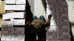 ケンタッキー州ルイビルで未記入の投票用紙の間に座る選管当局者