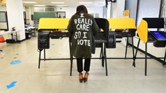 「本当に気になるから投票する」の文字があるジャケットを着て投票する女性。メラニア・トランプ氏が２０１８年に着た「私は本当に気にしない。あなたはどう？」のジャケットに類似＝１０月２９日、カリフォルニア州ノーウォーク
