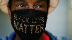 「黒人の命は大事」と書かれたマスクをして投票に臨む＝１０月１２日、アトランタのステート・ファーム・アリーナ