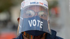 マスクとフェースシールドを着用して投票に臨む有権者＝３日、首都ワシントン