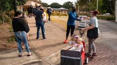 投票の列に並ぶ人に水やスナックを配る女性＝１０月２４日、ジョージア州スマーナ