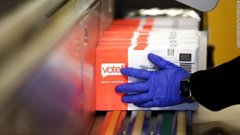 ワシントン州レントンで集票マシンに投票用紙をセットする作業員＝３日/JASON REDMOND/AFP via Getty Images