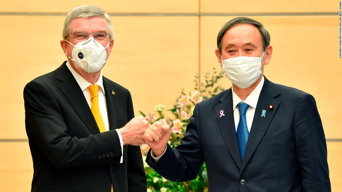 こぶしを突き合わせてあいさつするバッハ氏（左）と菅首相/KAZUHIRO NOGI/AFP/POOL/AFP via Getty Images