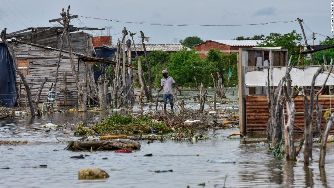 ハリケーンの通過後、浸水した区域を歩く住民/Vizzor Image/Getty Images