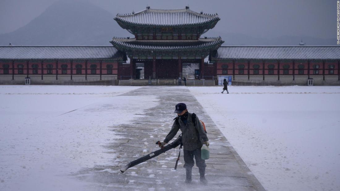 景福宮で除雪作業にあたる作業員/ED JONES/AFP/AFP via Getty Images