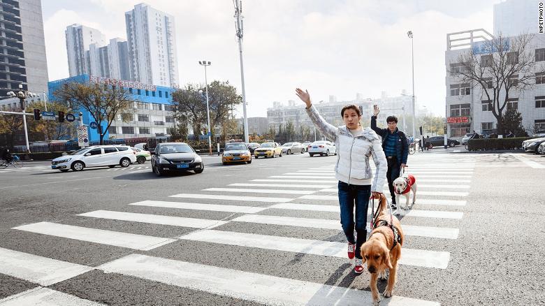 横断歩道をわたるるヤン・カンさん夫妻＝北京市/inpetphoto