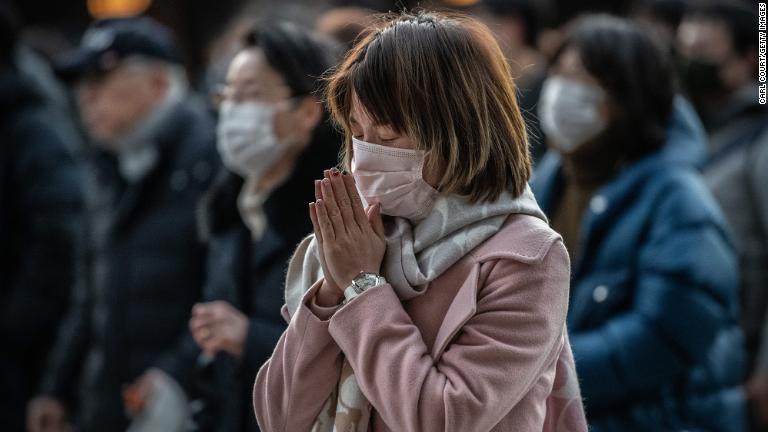 東京の明治神宮で初詣で祈る人々/Carl Court/Getty Images