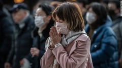 東京の明治神宮で初詣で祈る人々