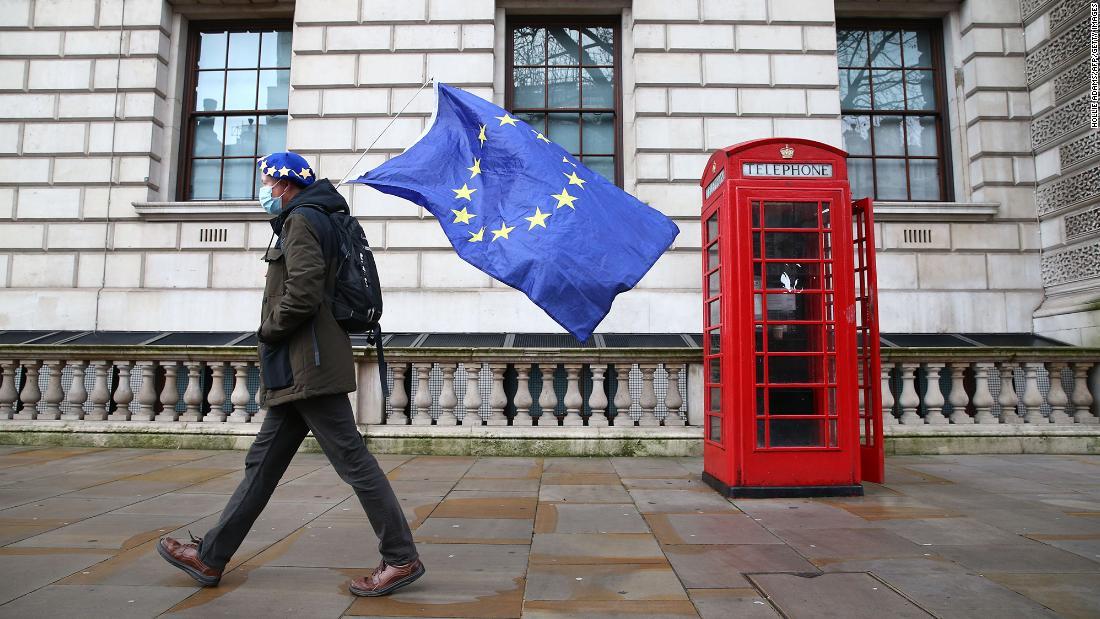 EUの旗を持って歩く男性=12月11日、ロンドン中心部ホワイトホール/Hollie Adams/AFP/Getty Images