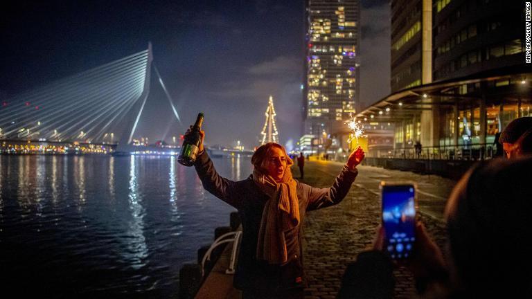 オランダ第２の都市ロッテルダムのエラスムス橋でお酒を片手に新年を祝う人/ANP/AFP/Getty Images