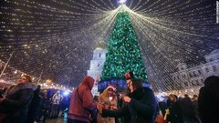 ウクライナ首都キエフでクリスマスツリーの光の装飾の下で祝う人々