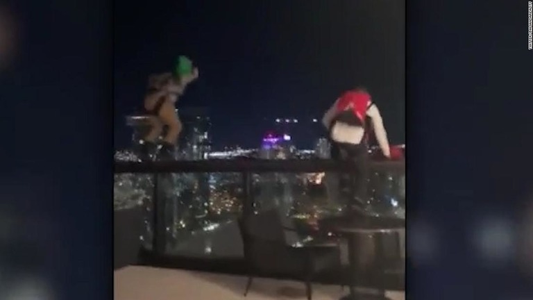 ホテルのフェンスによじ登る男性２人。この後、次々に飛び降りた/Twitter/@amandareality