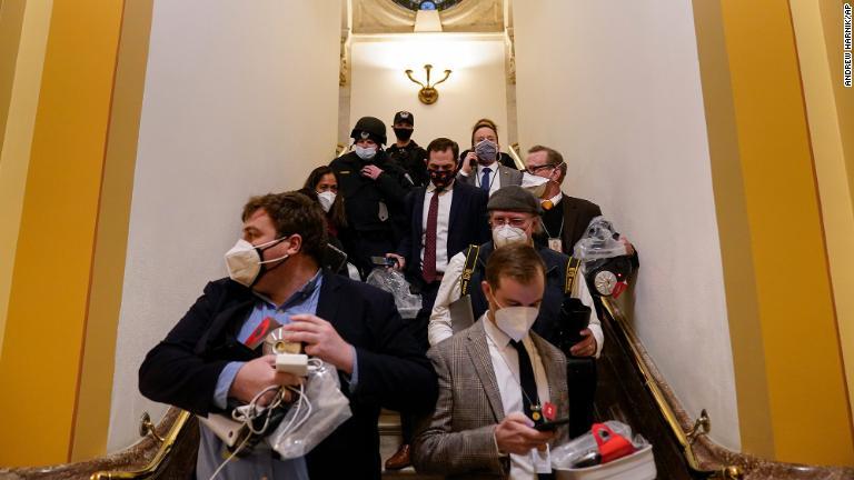暴徒が侵入しようとする中下院議場から退避/Andrew Harnik/AP