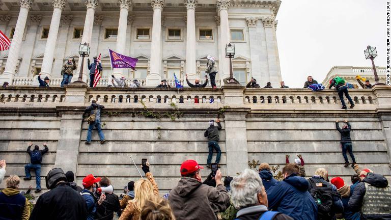 トランプ氏支持者が議事堂の外壁をよじ登る/Jason Andrew/The New York Times/Redux