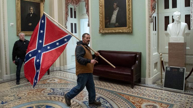 議事堂ロタンダで南部連合国の国旗を持つトランプ氏支持者。１８６４年の南北戦争中のスティーブンス砦（とりで）の戦いでも連合国旗は６マイル（約９．６キロ）より近づいたことはなかった/Saul Loeb/AFP/Getty Images