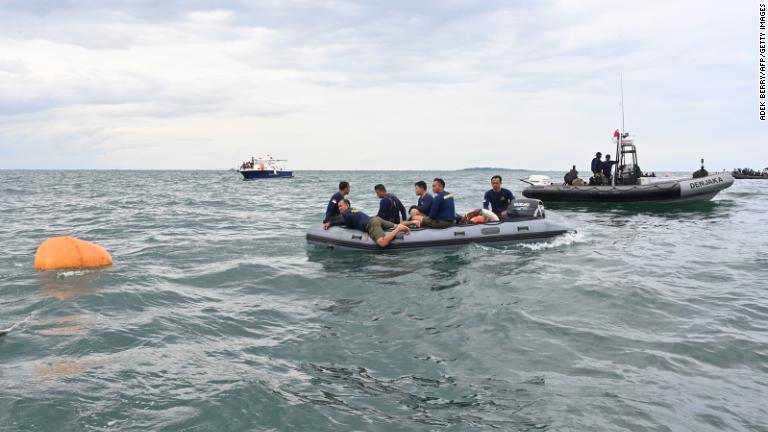 海軍のダイバーがランカン島付近で残骸の回収に浮遊式の装置を使用＝１０日/Adek Berry/AFP/Getty Images