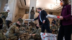 議事堂のビジターセンターにいる州兵にピザを届ける共和党のマイケル・ウォルツ議員とビッキー・ハーツラー議員