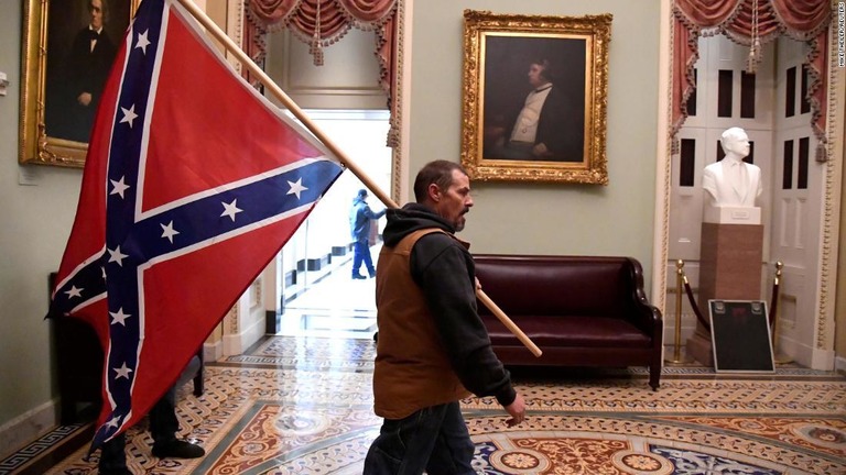 南部連合（南軍）の旗を持つ男＝６日、米連邦議会議事堂/Mike Theiler/Reuters