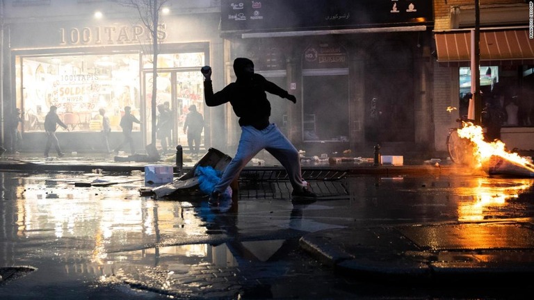 ブリュッセルの警察署に向かって石を投げる抗議者＝１３日、ベルギー/Francisco Seco/AP