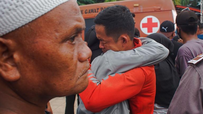 地震の後、互いを慰め合う人々/Azhari Surahman/AP