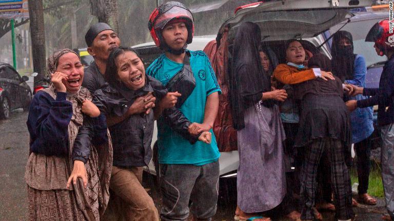 親族の救出作業を見守る人々/Yusuf Wahil/AP