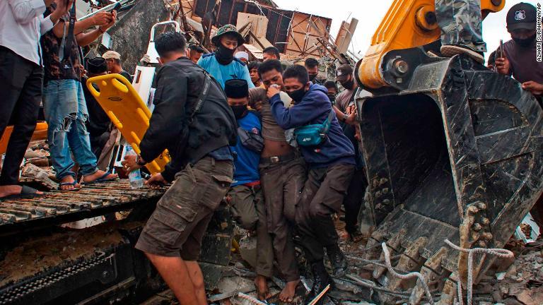 インドネシア・西スラウェシ州マムジュで、倒壊した政府の建物から救出される生存者/Azhari Surahman/AP
