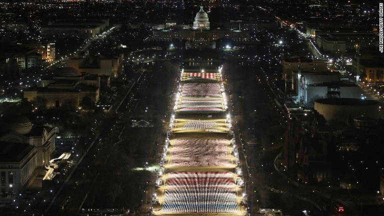 ナショナルモールに並ぶ国旗をライトアップ＝１８日/Joe Raedle/Getty Images