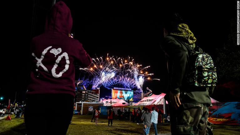 スタジアムの外から花火を見るファン/Chandan Khanna/AFP/Getty Images