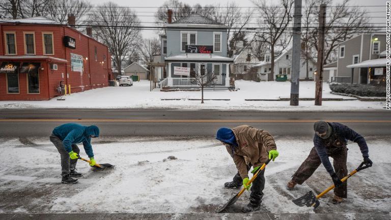 店の前の雪かきをする人たち＝１５日、ケンタッキー州ルイビル/Pat McDonogh/Courier Journal/USA Today Network