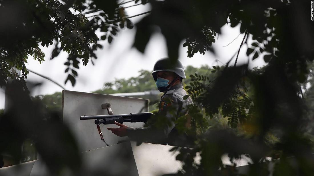 デモ参加者に銃を向ける警官/AFP/Getty Images