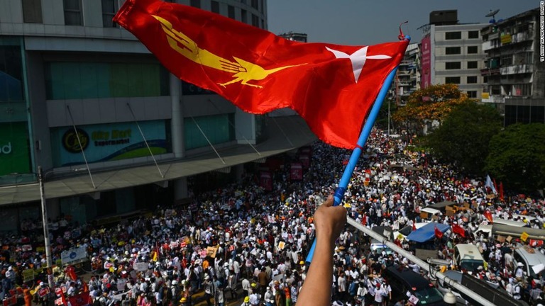 デモ参加者らと国民民主連盟（ＮＬＤ）の旗＝２２日、ミャンマー・ヤンゴン/Ye Aung Thu/AFP/Getty Images