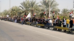 バグダッド市民が道路脇に集まり、フランシスコ教皇の車列の到着を待つ