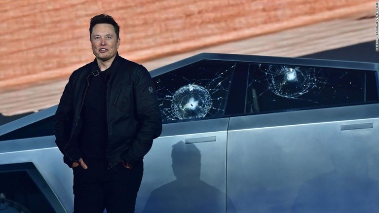 ガラスにひびが入ったサイバートラックと写真に納まるテスラのイーロン・マスクＣＥＯ＝１９年１１月/Frederic J. Brown/AFP/Getty Images