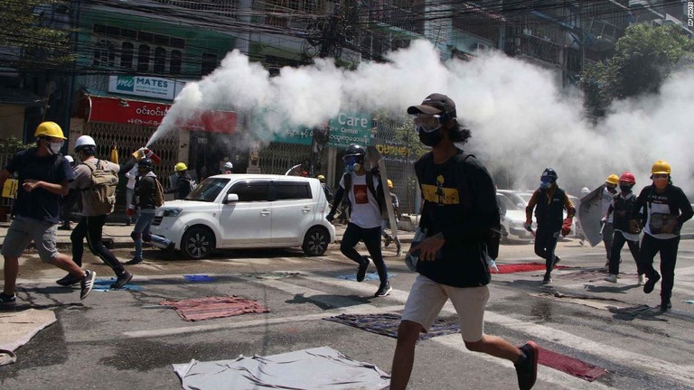 警察の使用する催涙ガスに対抗して消火器を放出するヤンゴンの抗議デモ参加者ら/AP Photo