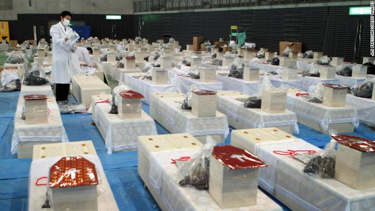震災の犠牲になった人の遺体を収めた棺が並ぶ。宮城県利府町/JIJI PRESS/AFP/Getty Images