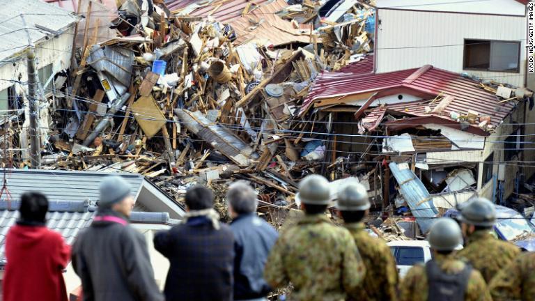 震災の翌日、被害状況を確認する人々。宮城県気仙沼市/Kyodo News/Getty Images