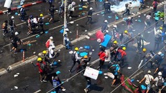 催涙ガスが発射され逃げるデモ参加者＝１日、ヤンゴン