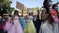 ウェディングドレスを着てプラカードを掲げて抗議デモに参加する女性たち＝２月１０日、ヤンゴン